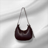 Brown handbag on a reflective silver background