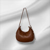 Brown leather handbag on a light gray background